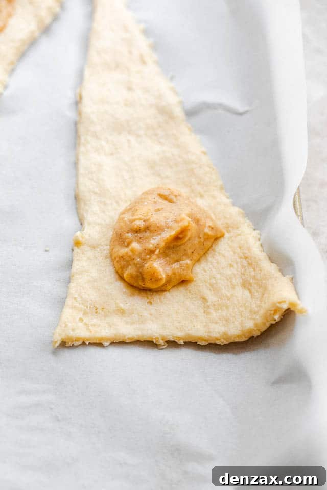 unrolled raw crescent dough with a dollop of pumpkin filling