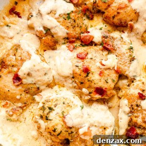 Creamy Garlic Chicken Thighs with Mushroom Sauce 2 top view of cooked cream sauce chicken thighs in a white skillet with a silver serving spoon picking up the food