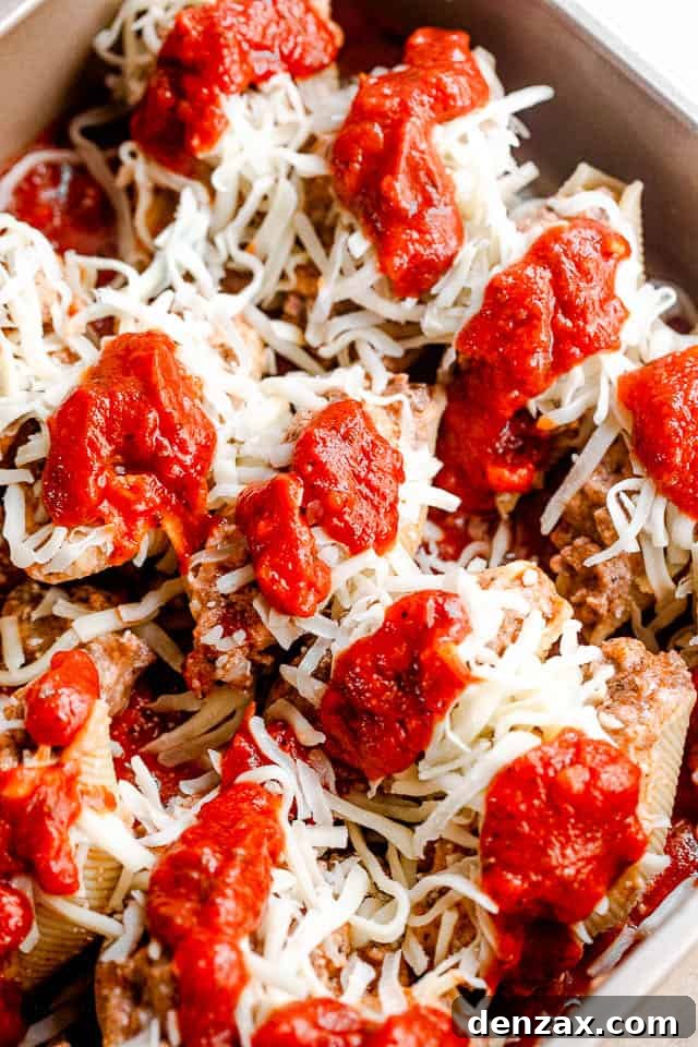 Stuffed pasta shells with a savory beef and ricotta filling, baked in marinara and topped with melted cheese. It’s like lasagna in shells! preparing lasagna stuffed pasta shells for baking