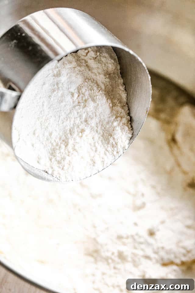 side shot of a silver measuring cup filled with flour
