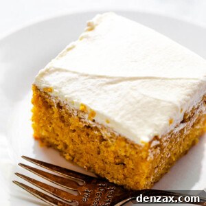 side shot of frosted pumpkin bar on a plate with a fork next to it