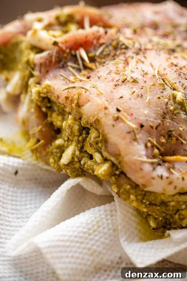 side shot of raw pork chop stuffed with pesto and feta cheese