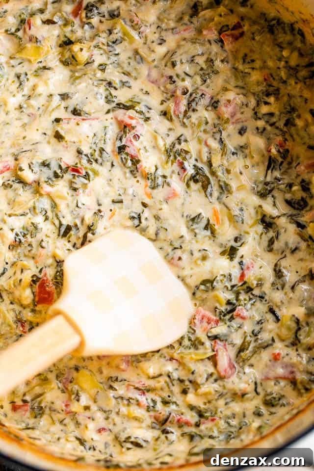 mixing spinach artichoke dip with a spatula