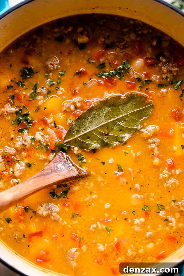 Overhead, close-up image of butternut squash soup cooking in a Dutch oven.
