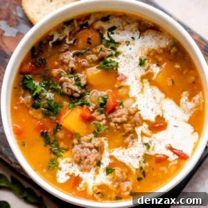 overhead shot of butternut squash and sausage soup in a white soup bowl