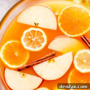 overhead close up shot of apple cider punch in a punch bowl with slices of fruit floating on top
