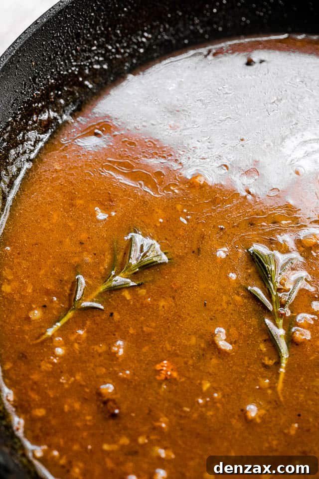 apple cider glaze cooking in a black skillet