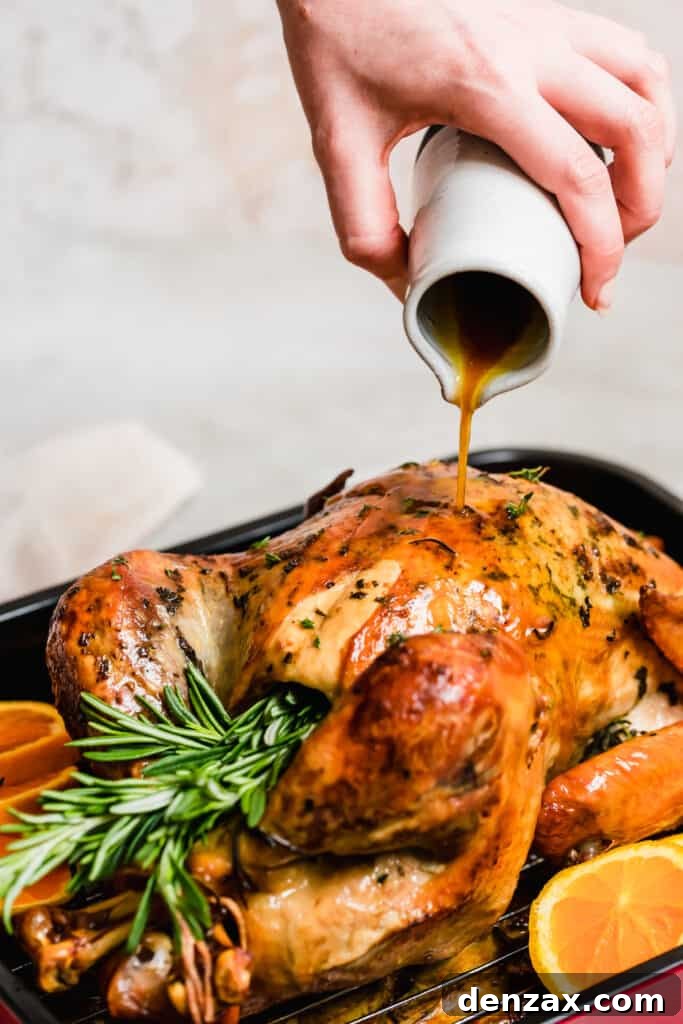 Basting a roasted turkey in a pan.
