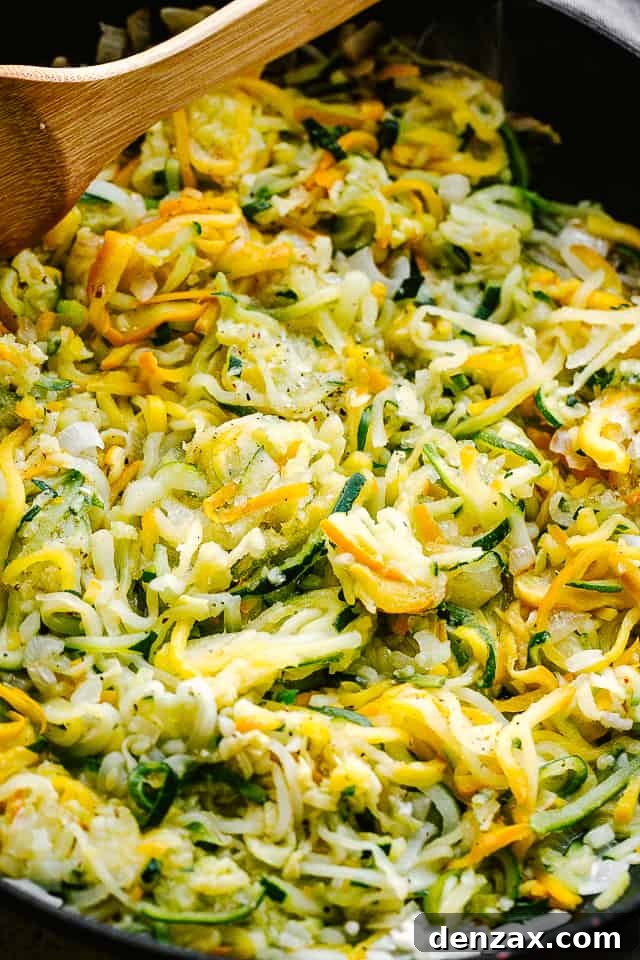 sauteeing spiralized zucchini in a black frying pan