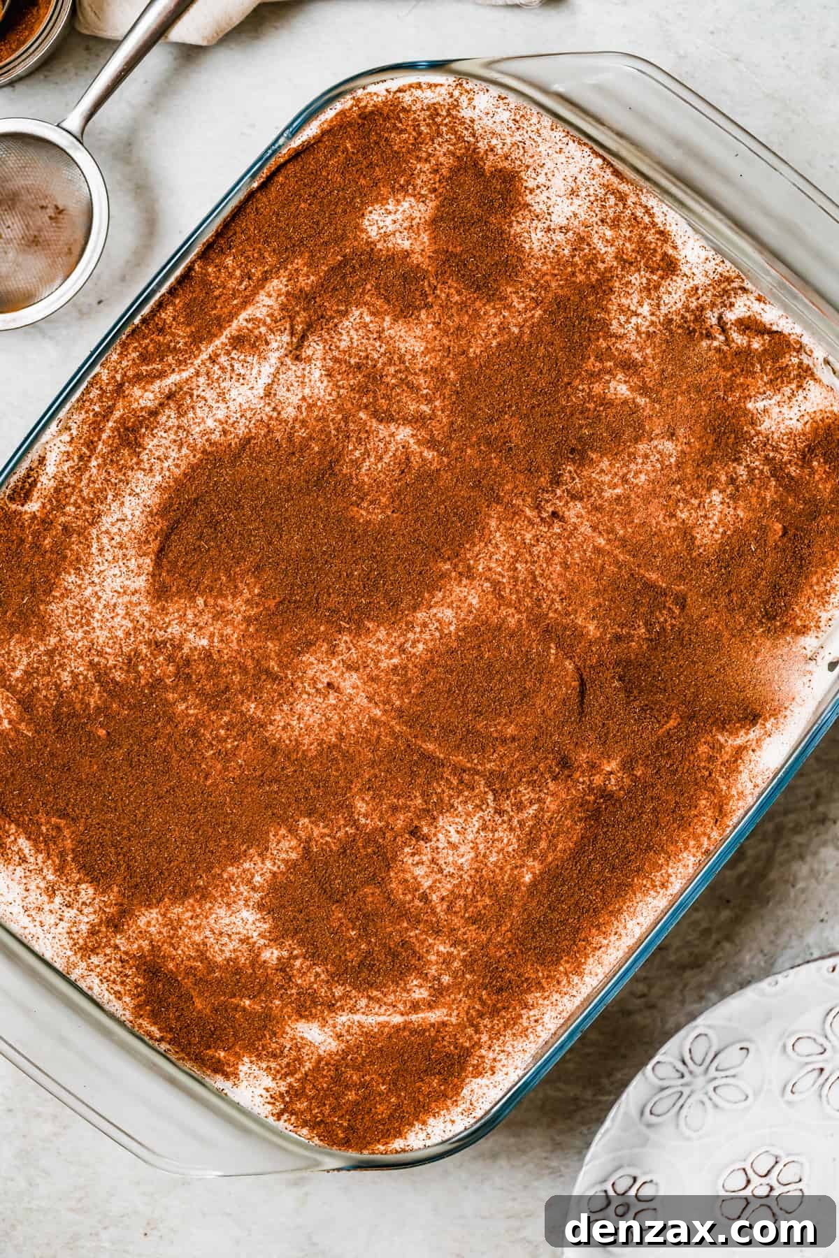 Cinnamon topped tres leches cake in a baking pan.