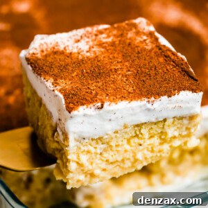 Lifting out a piece of tres leches cake from a glass baking dish.