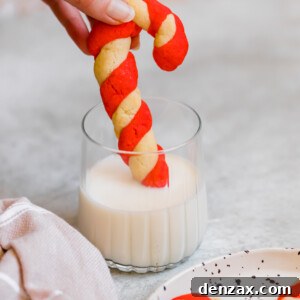 A Candy Cane Cookie Being Dipped into a Cold Glass of Milk