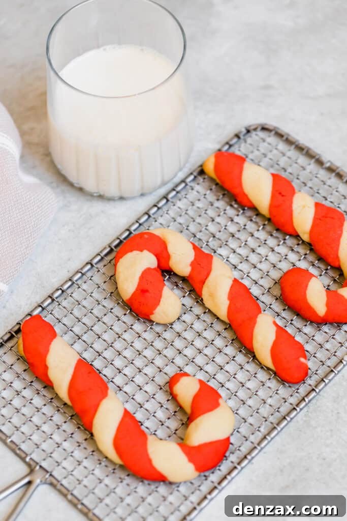 Three Candy Cane Cookies on a Granite Countertop Next to Santa's Milk