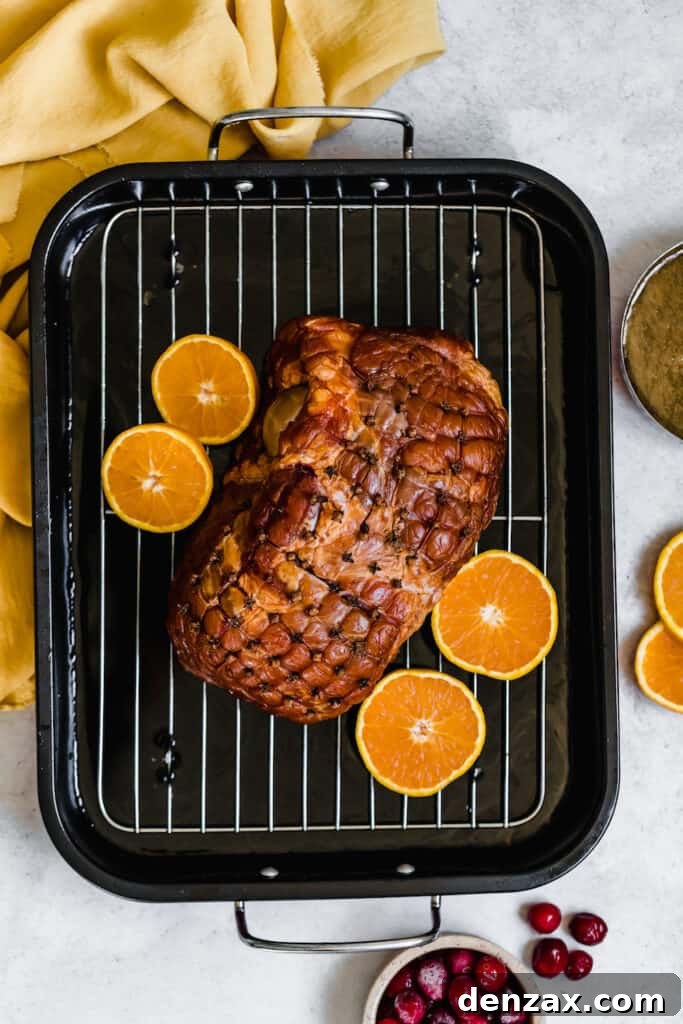A Christmas Ham on a Roasting Pan with Four Orange Slices