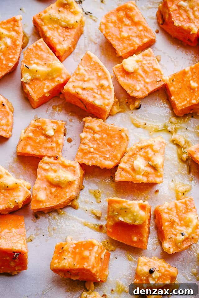 overhead shot of chopped raw sweet potatoes on parchment paper