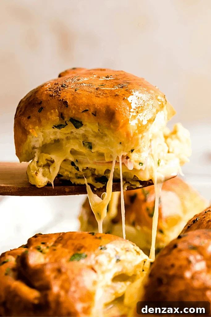 Ham and Swiss Sliders with Honey-Mustard Glaze 2 A Hot Ham and Cheese Slider on a Wooden Serving Spatula