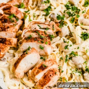 A Close-Up Shot of Sliced Chicken Breasts and Fettuccine Pasta with Alfredo Sauce