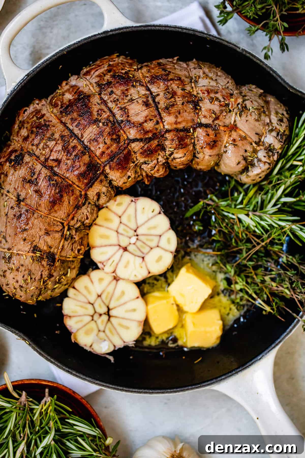 Roast Tenderloin, Garlic Cloves, Rosemary and Butter in a Metal Skillet