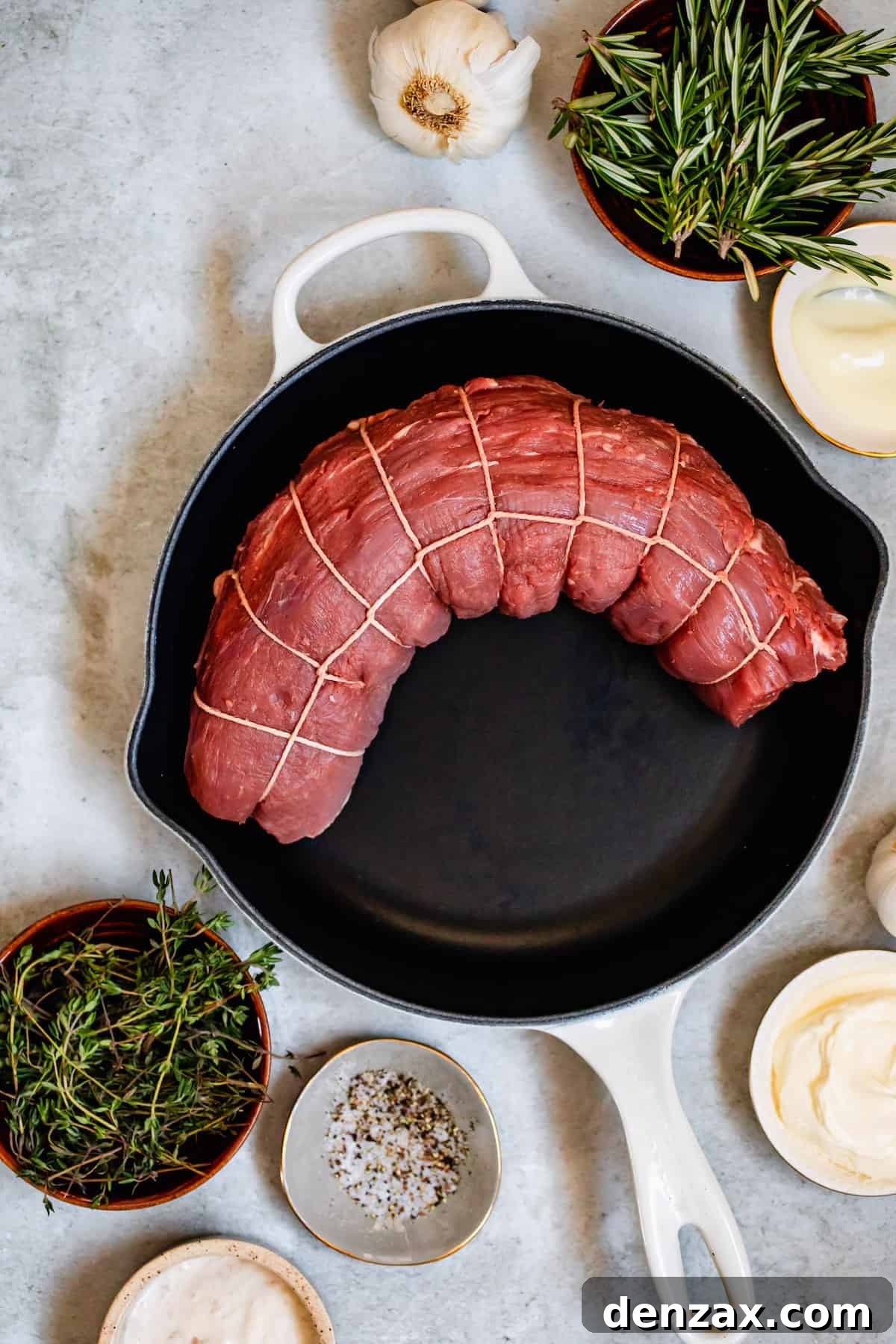 A Tied Beef Tenderloin in a Skillet Next to the Other Recipe Ingredients
