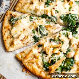 side shot of sliced chicken alfredo pizza