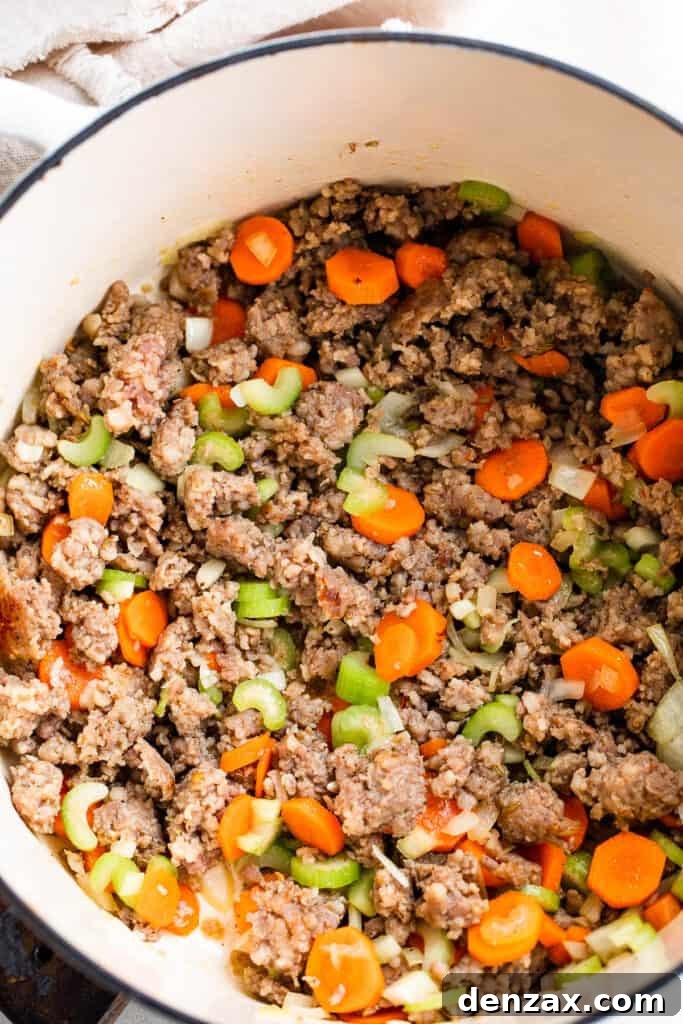 cooking Italian sausage in a white dutch oven