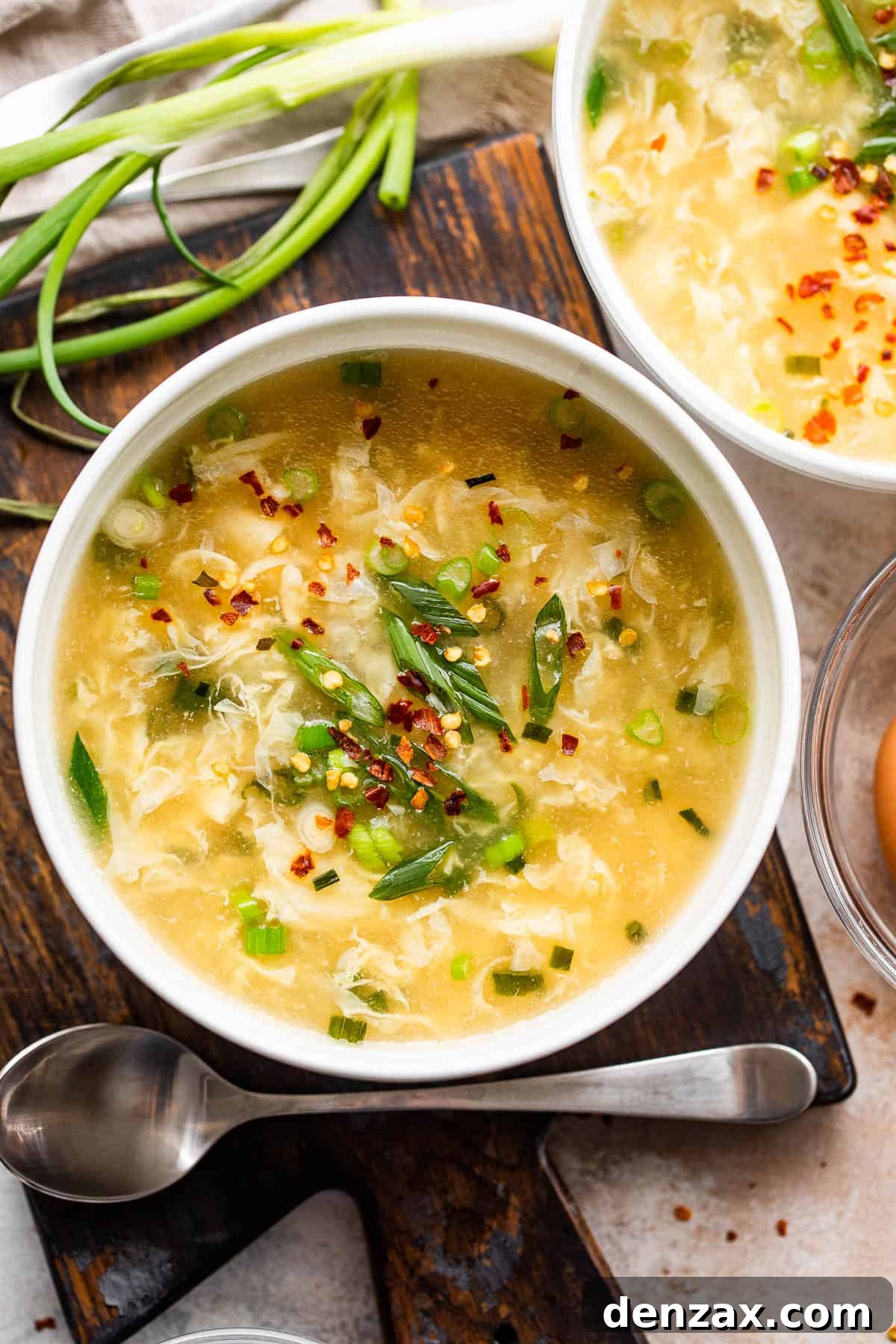 Whip up this simple egg drop soup in just 15 minutes—it might even taste better than the one from your go-to Chinese spot! egg drop soup served in two white bowls