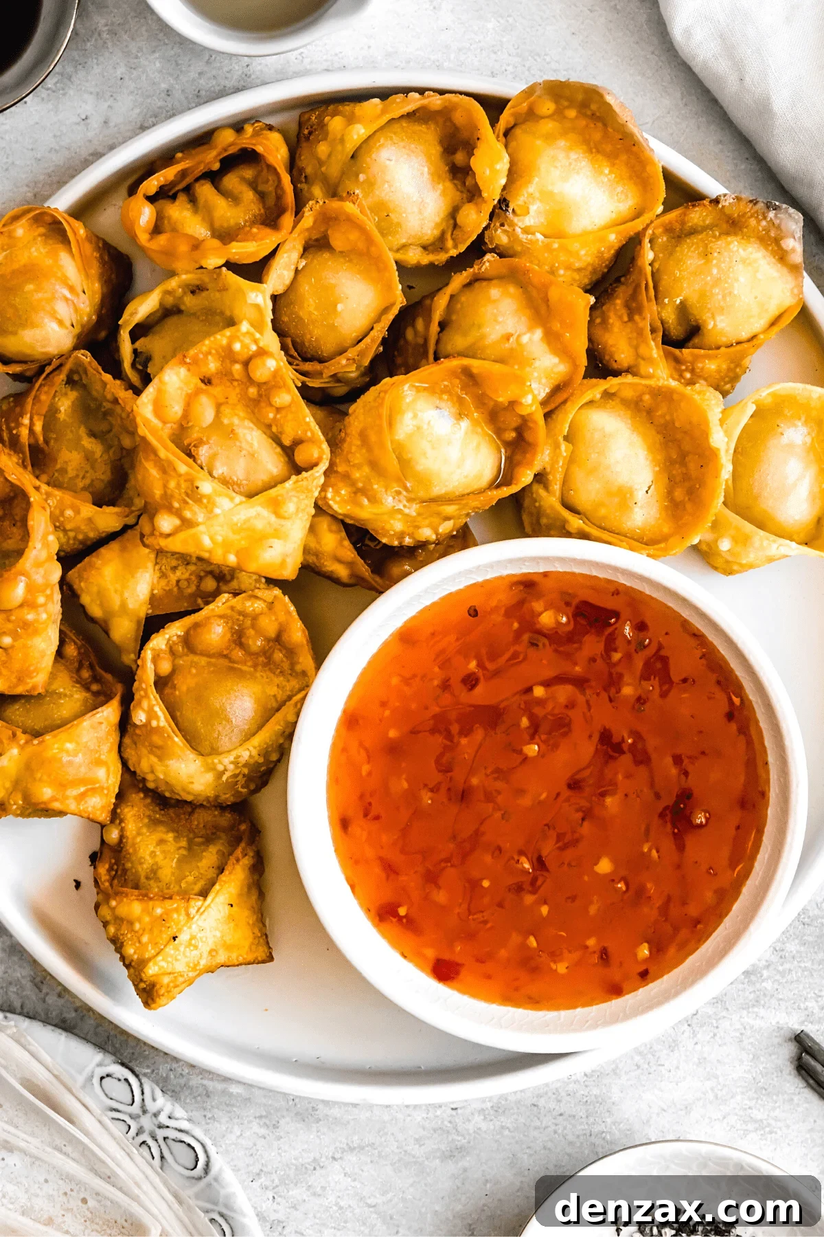 Crispy Crab Rangoon Wontons Recipe: Creamy Crab-Filled Appetizers 3 crab rangoon wontons arranged on a plate with a dipping sauce