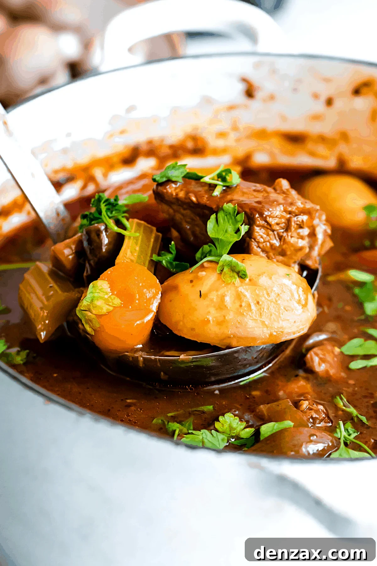 Rich Guinness Beef Stew Recipe for Comforting Dinner 11 ladling out beef stew from a dutch oven