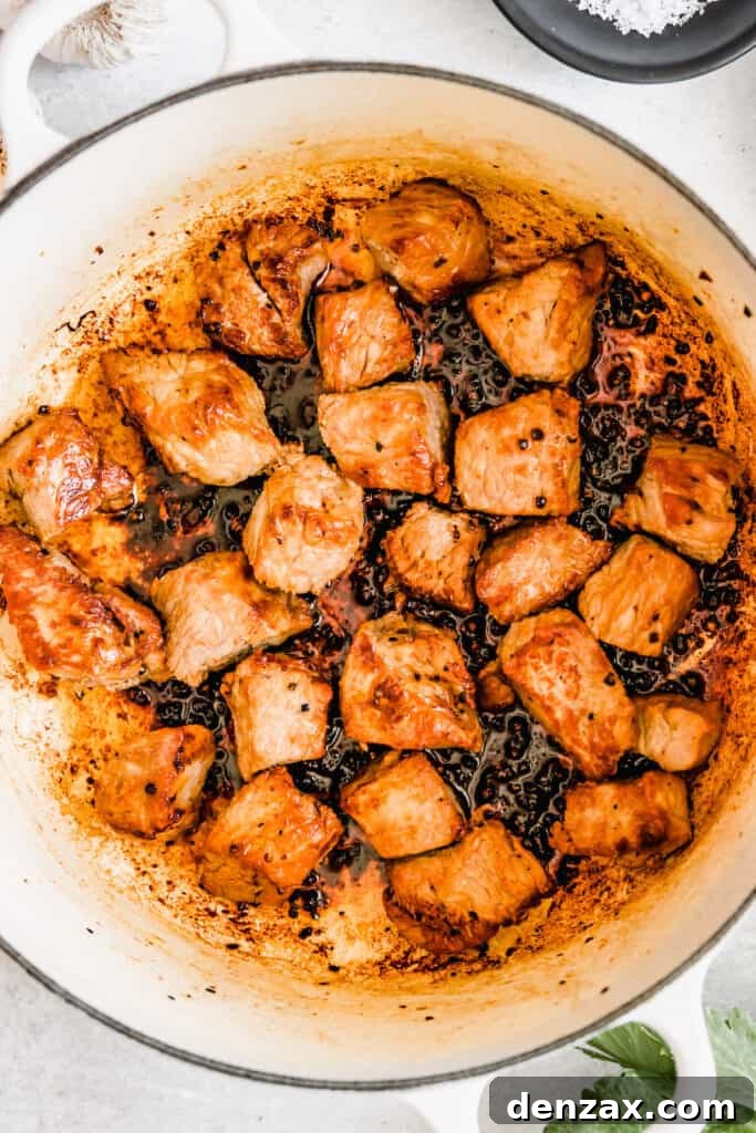 Rich Guinness Beef Stew Recipe for Comforting Dinner 7 Chunks of beef cooking in a pot.