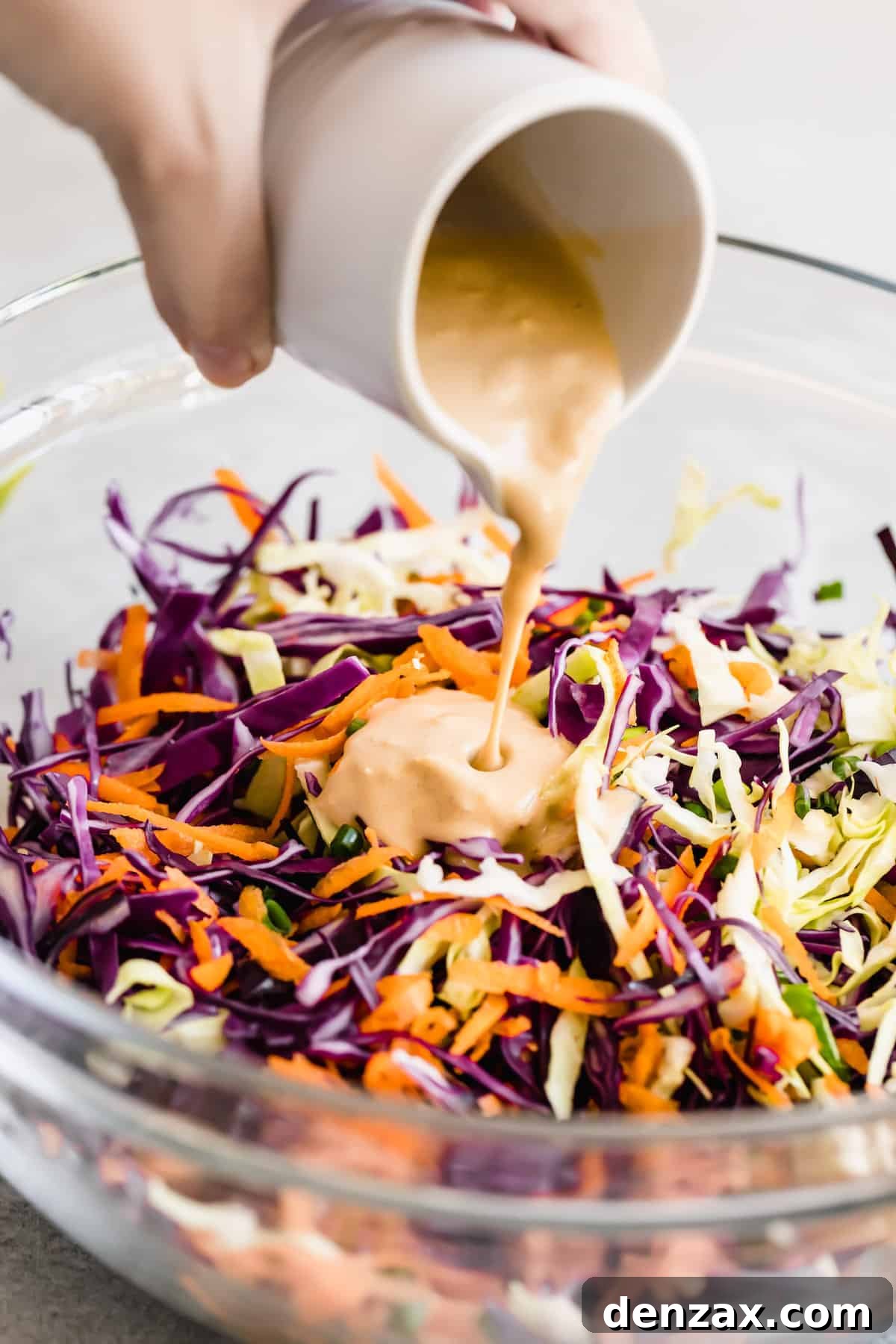 Asian Dressing Being Poured Over the Cabbage Slaw Mixture