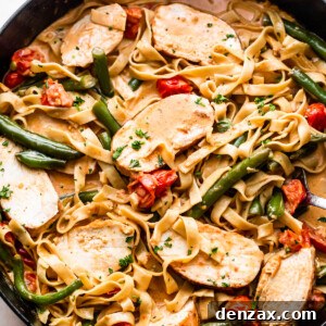 overhead shot of a skillet with Creole Blackened Chicken with Pasta, tomatoes, and green beans