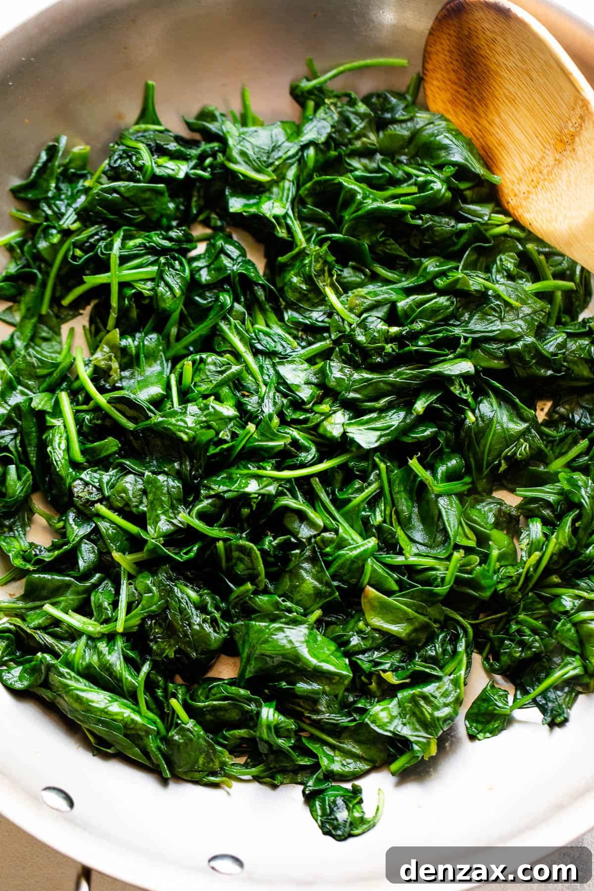 Creamed Spinach is a creamy, gourmet side dish prepared with buttery wilted spinach in a homemade velvety butter sauce. cooking spinach in stainless steel skillet
