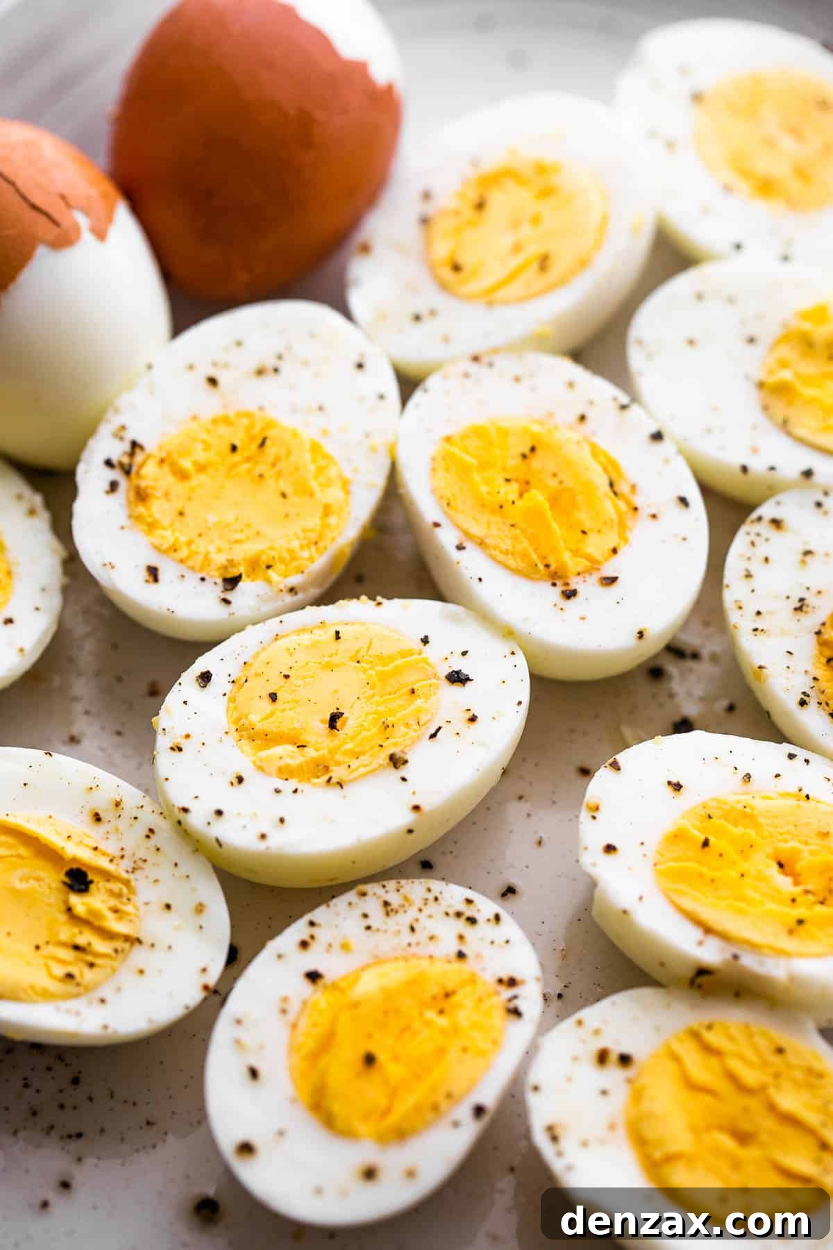 halved hard boiled eggs topped with cracked black pepper