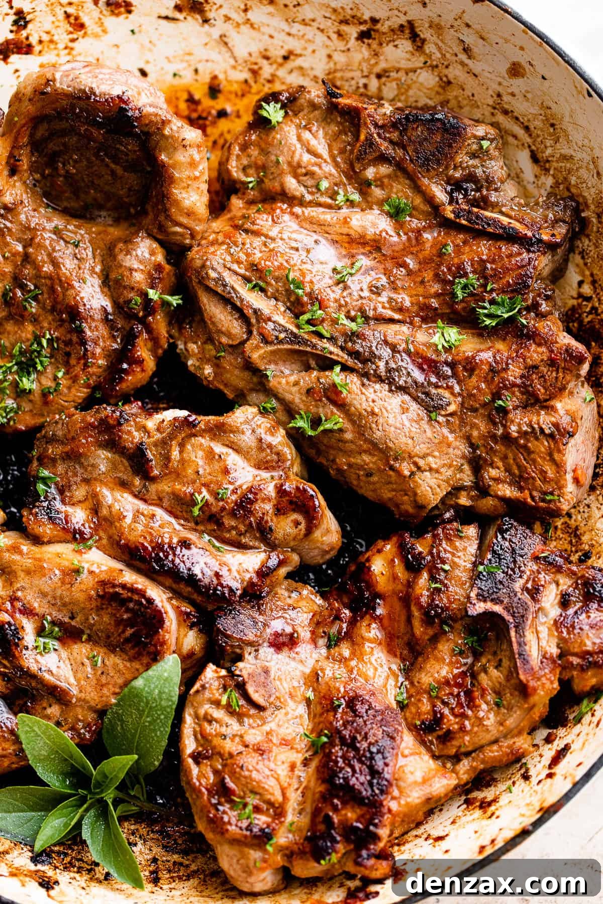 close up shot of cooked lamb chops with mint sprig on the side