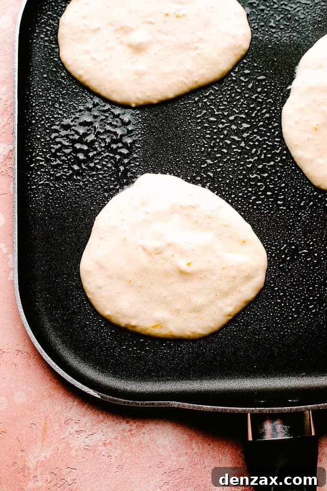 Cooking fluffy pancakes on a griddle Making fluffy pancakes on a hot griddle