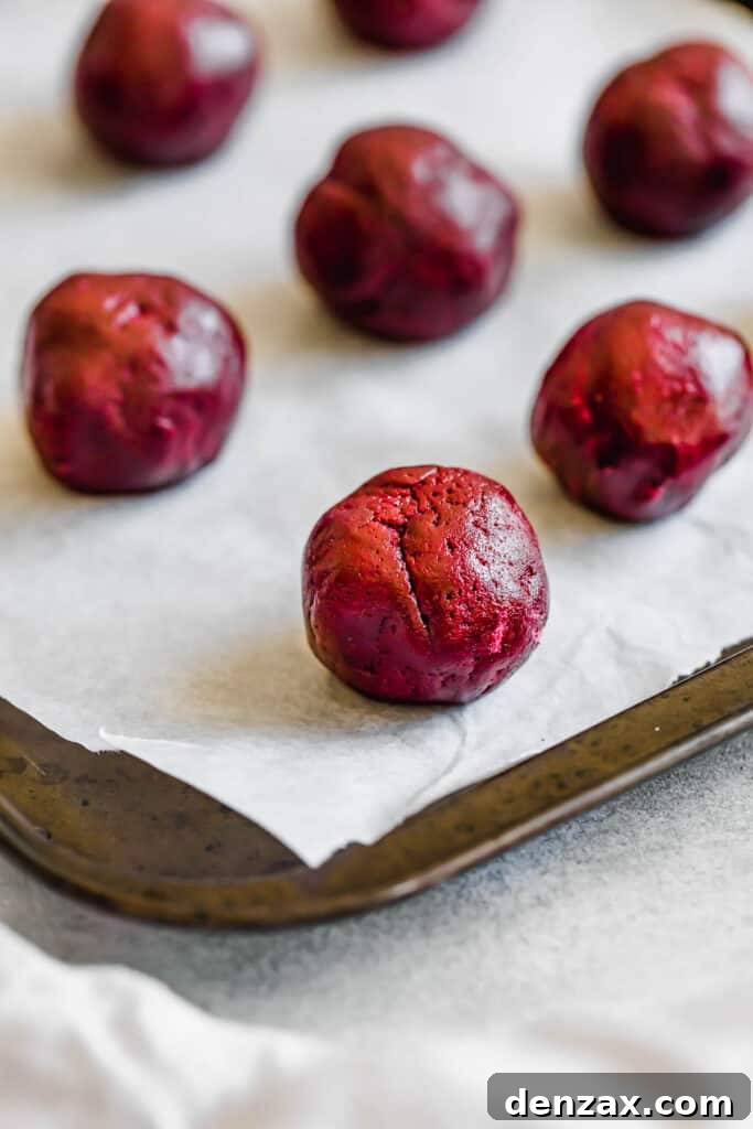 A Ball of Red Velvet Cookie Dough Coated in Granulated Sugar