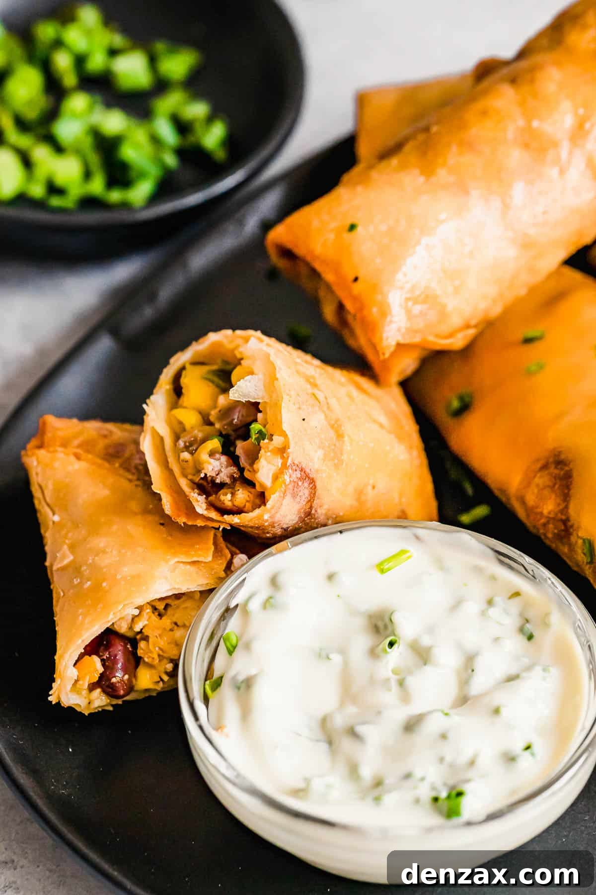 A Plate of Egg Rolls with a Glass Dish of Dipping Sauce