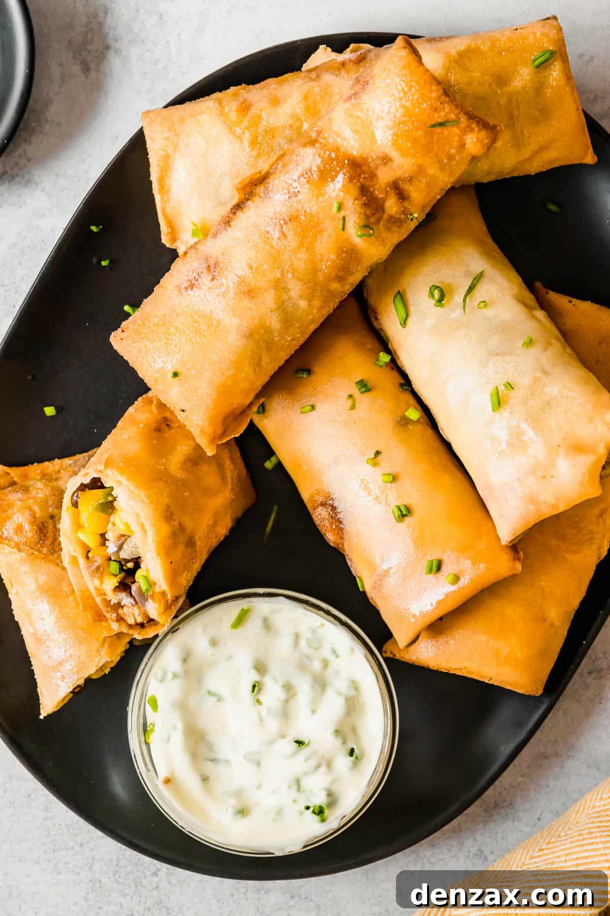 A Plate of Egg Rolls with a Glass Dish of Dipping Sauce