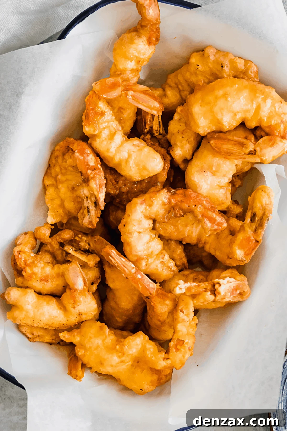 A White Serving Platter with a Blue Rim Holding Pan Fried Shrimp