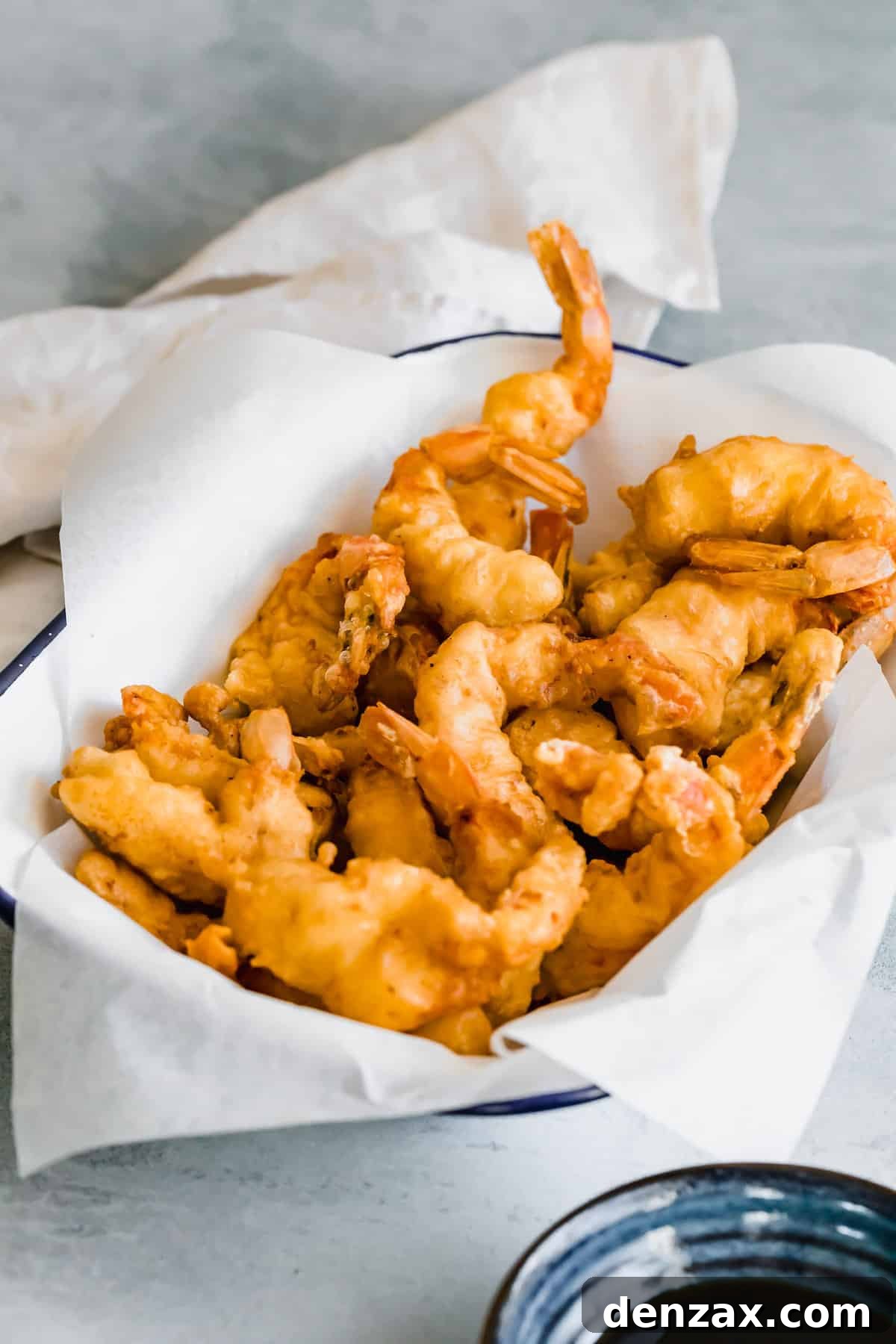 A Parchment-Lined Serving Platter Containing Pan-Fried Shrimp Tempura