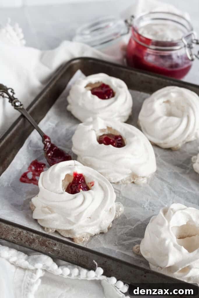 Pavlova nests being filled with strawberry filling