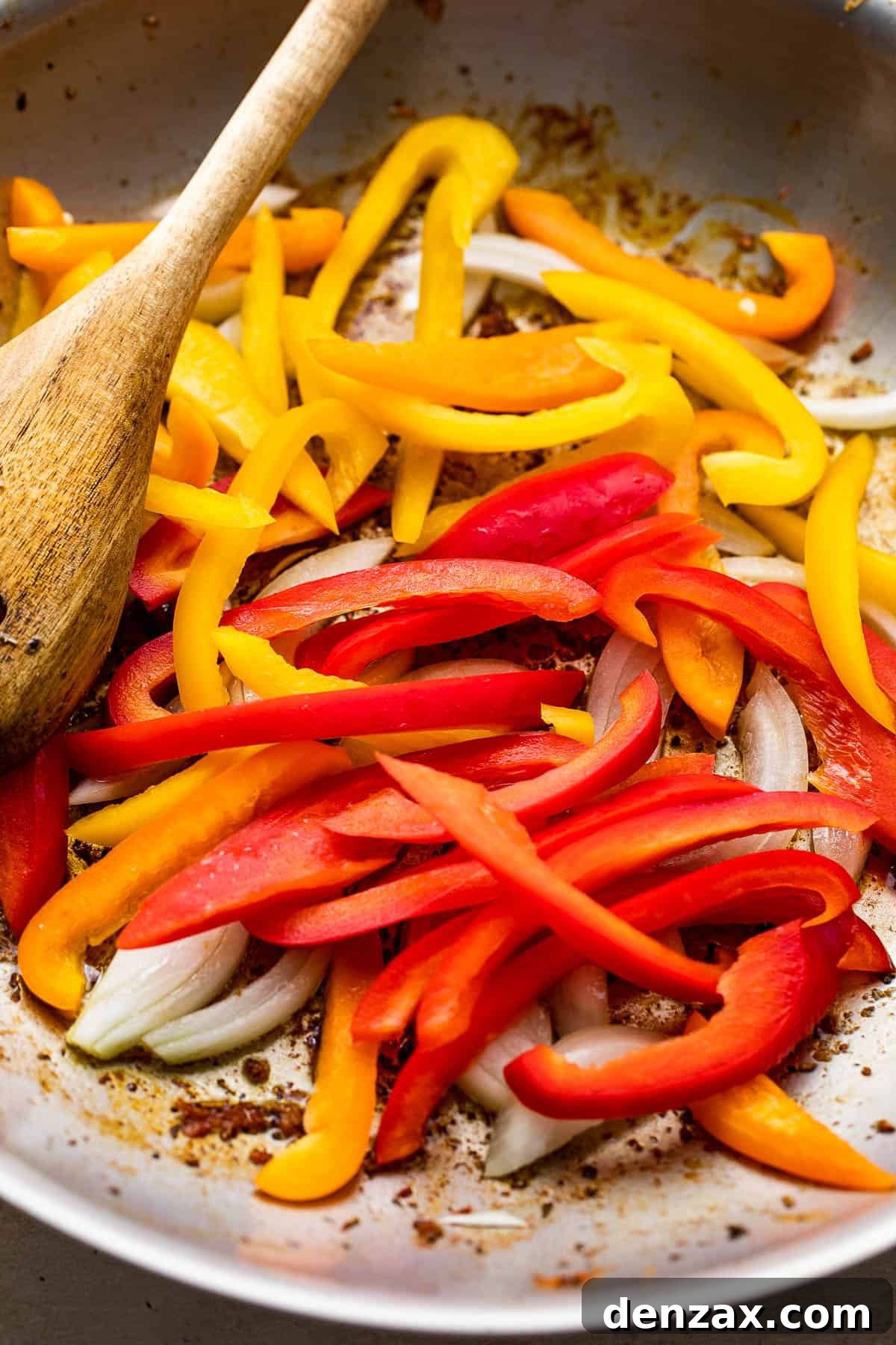 sauteeing bell pepper strips and onions in a skillet