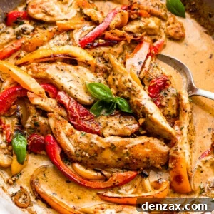 overhead shot of a skillet with creamy pesto chicken strips, peppers, and cream sauce