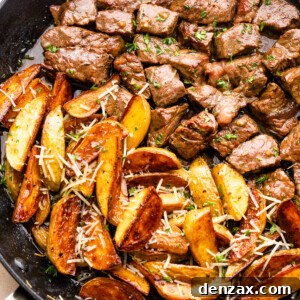 cubed steak and quartered potatoes cooking in a skillet