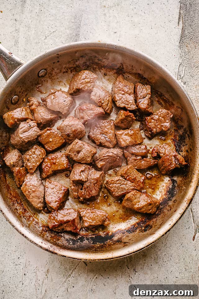 Searing beef tips in a hot skillet