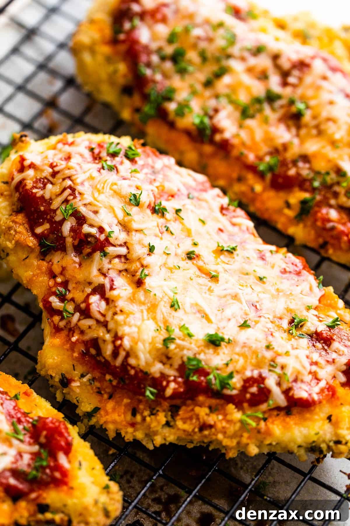 A Close-Up Shot of a Piece of Chicken Parmesan on Top of a wire rack