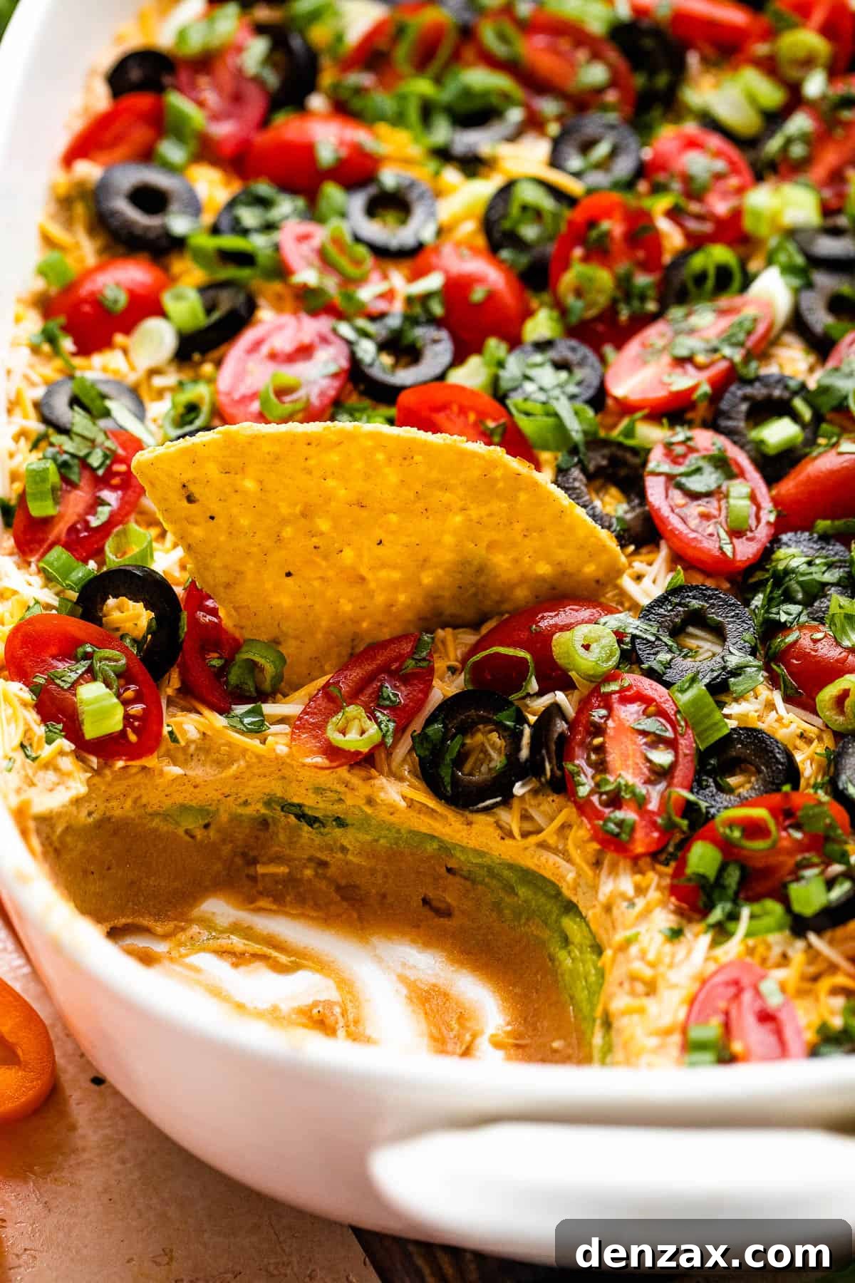 side shot of a white baking dish with seven layer mexican dip