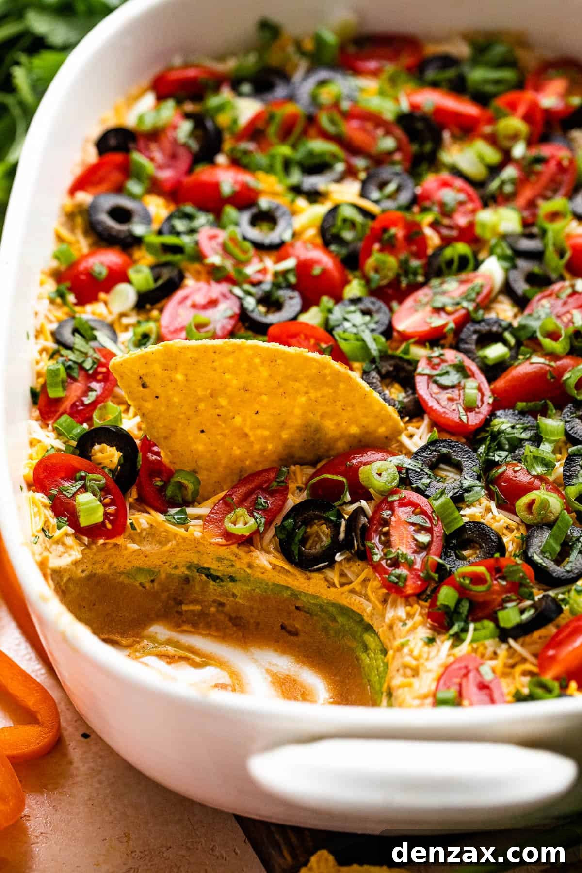 side shot of a white baking dish with seven layer mexican dip