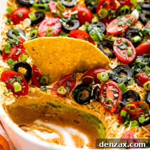 side shot of a white baking dish with seven layer mexican dip