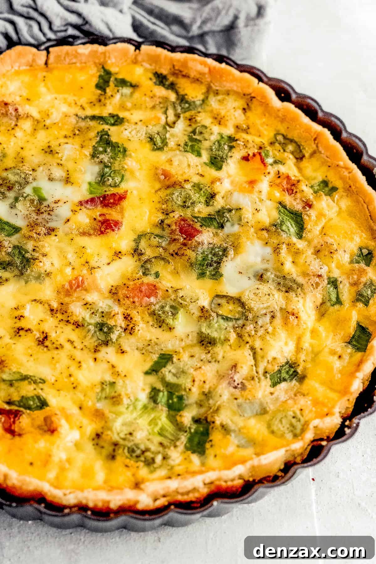 A Freshly Baked Quiche Lorraine Inside of a Black Quiche Pan